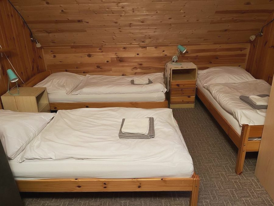 Pokoj se třemi postelemi a nočními stolky